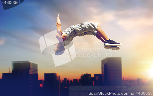 Image of man making parkour jumping over tokyo city