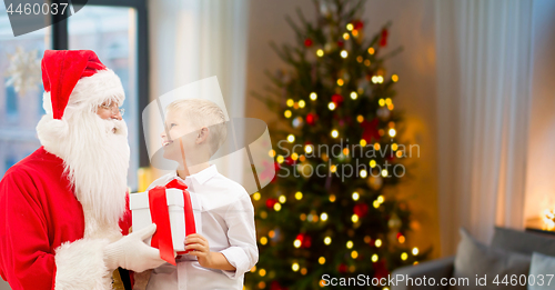 Image of boy and santa with christmas gifts at home