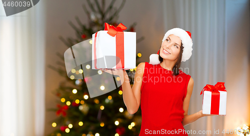 Image of smiling woman in santa hat with christmas gifts