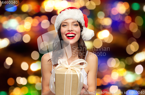 Image of woman in santa hat with christmas gift