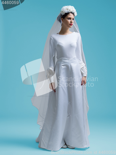 Image of beautiful woman wearing wedding dress against cyan background