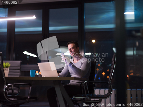 Image of man working on laptop in dark office