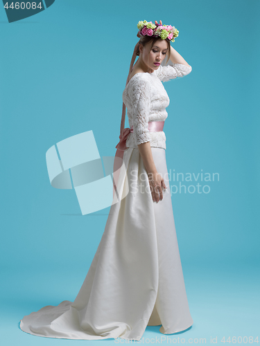 Image of beautiful woman wearing wedding dress against cyan background