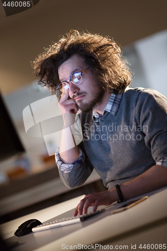 Image of man working on computer in dark office