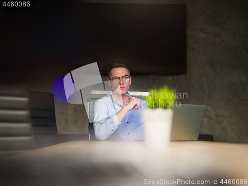 Image of man working on laptop in dark office