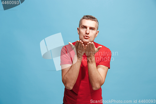 Image of Portrait of attractive man with kiss isolated over blue background