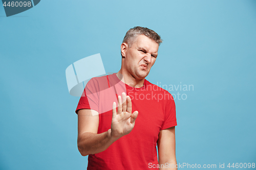 Image of Let me think. Doubtful pensive man with thoughtful expression making choice against blue background