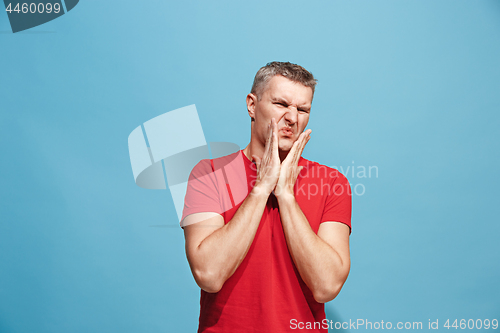 Image of Let me think. Doubtful pensive man with thoughtful expression making choice against blue background