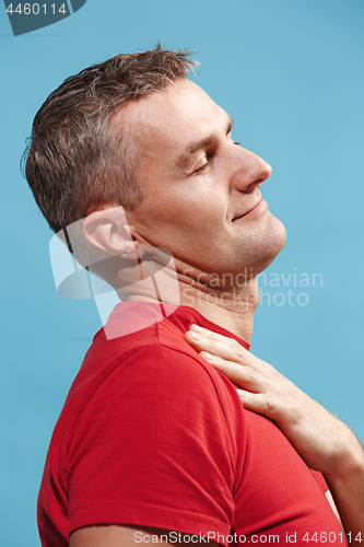 Image of The happy businessman standing and smiling against blue background.