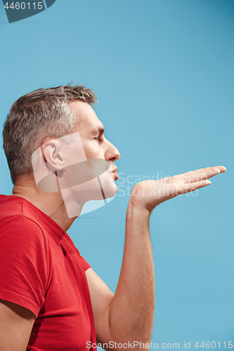 Image of Portrait of attractive man with kiss isolated over blue background