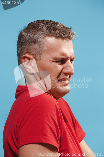 Image of Let me think. Doubtful pensive man with thoughtful expression making choice against blue background