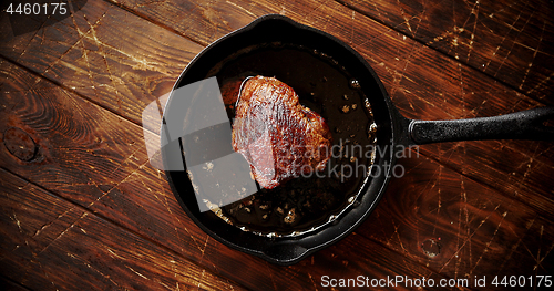 Image of Piece of meat fried in oil on pan
