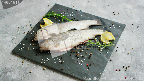 Image of Spices and lemon lying near uncooked fish