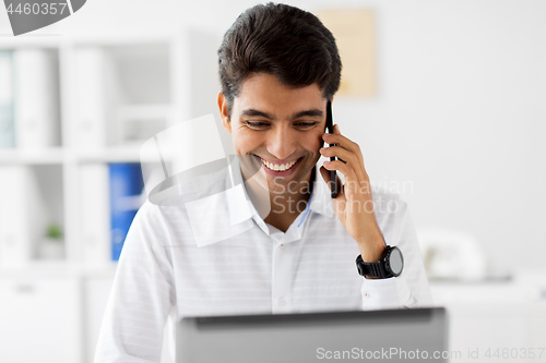 Image of businessman calling on smartphone at office