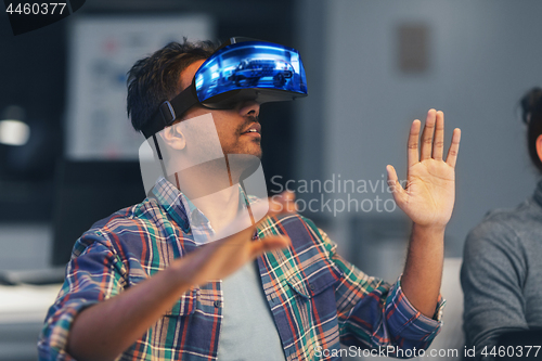 Image of man in virtual reality headset at night office