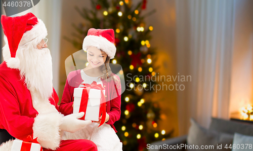 Image of girl and santa with christmas gifts at home