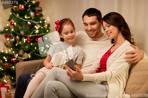 Image of family with smartphone at home on christmas