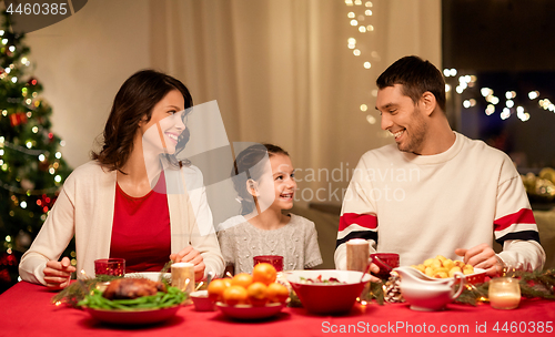 Image of happy family having christmas dinner at home