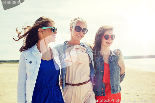 Image of group of smiling women in sunglasses on beach