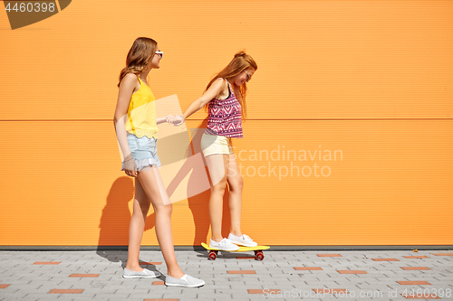 Image of teenage girls riding skateboard on city street