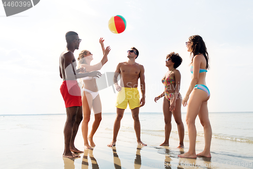 Image of friends playing with beach ball in summer