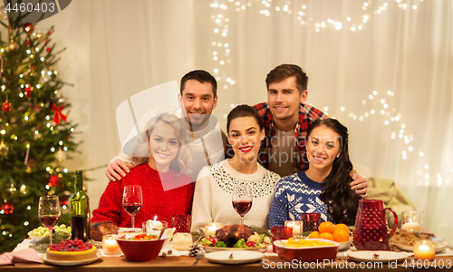 Image of happy friends celebrating christmas at home