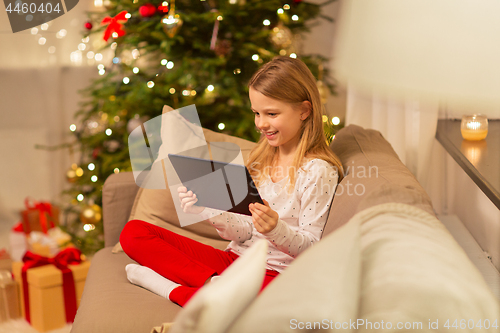 Image of smiling girl with tablet pc at christmas home