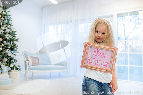 Image of Cute girl standing near Christmas Tree