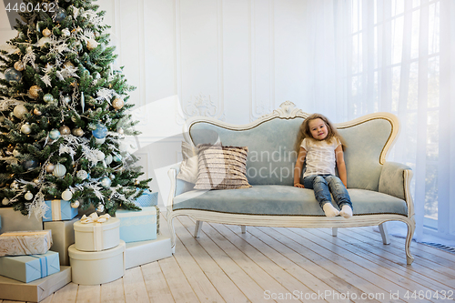 Image of Beautiful girl sitting on the sofa near