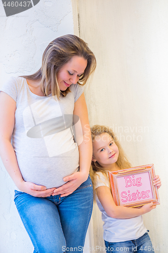 Image of Beautiful pregnant woman standing near wall