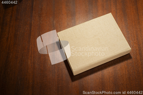 Image of Beige color book on the wooden scratched table.