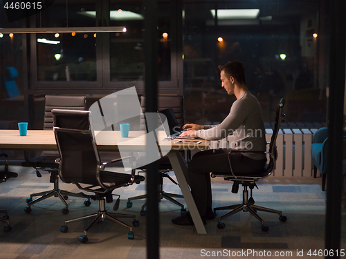 Image of man working on laptop in dark office