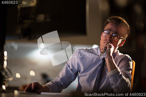 Image of man working on computer in dark office