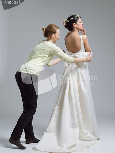 Image of Beautiful young bride wears dress by stylist