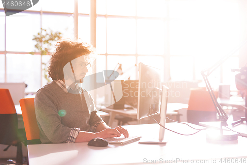 Image of Young businessman using computer at work