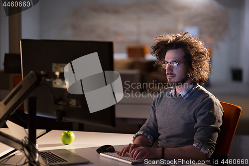 Image of man working on computer in dark office