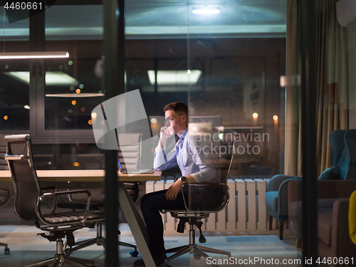 Image of man working on laptop in dark office