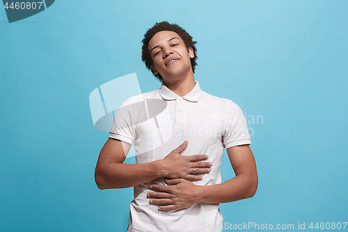 Image of The happy business man standing and smiling against blue background.