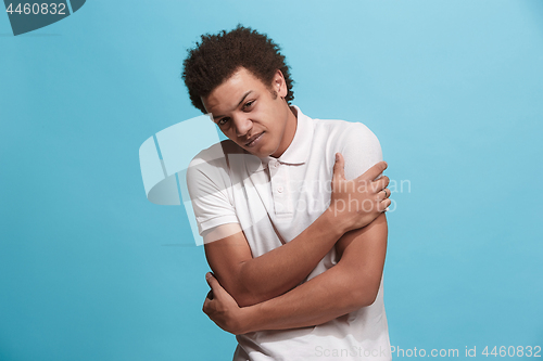 Image of Young man overwhelmed with a pain in the shoulder.