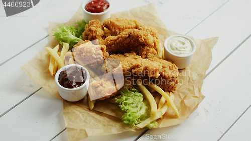 Image of Sauces and chicken wings on parchment