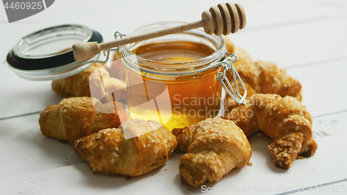 Image of Jar with honey and croissants