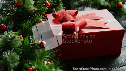 Image of Christmas present near conifer branches with beads