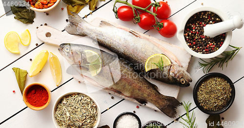 Image of Aromatic spices and vegetables around fish