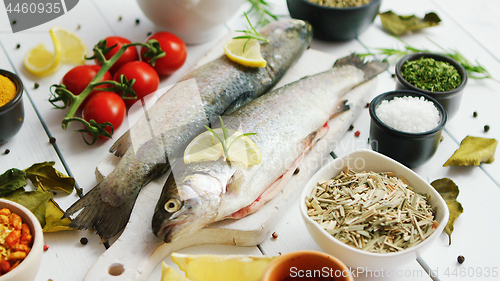 Image of Spices and tomatoes around fish