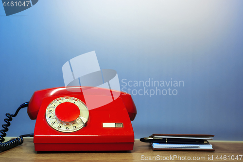 Image of Outdated red rotary dial telephone