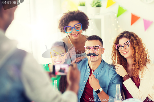 Image of friends or team photographing at office party