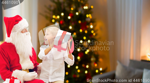 Image of boy and santa with christmas gifts at home