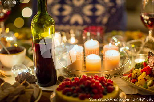 Image of food, drinks and candles burning on table