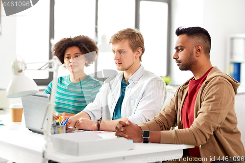 Image of creative team with laptop working at office