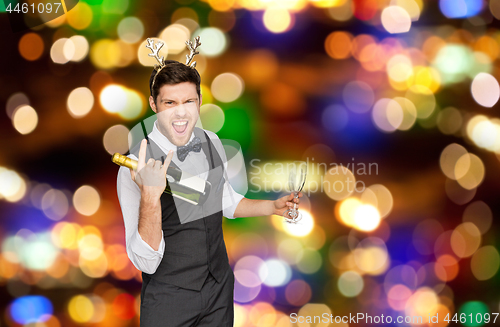 Image of man with bottle of champagne at christmas party